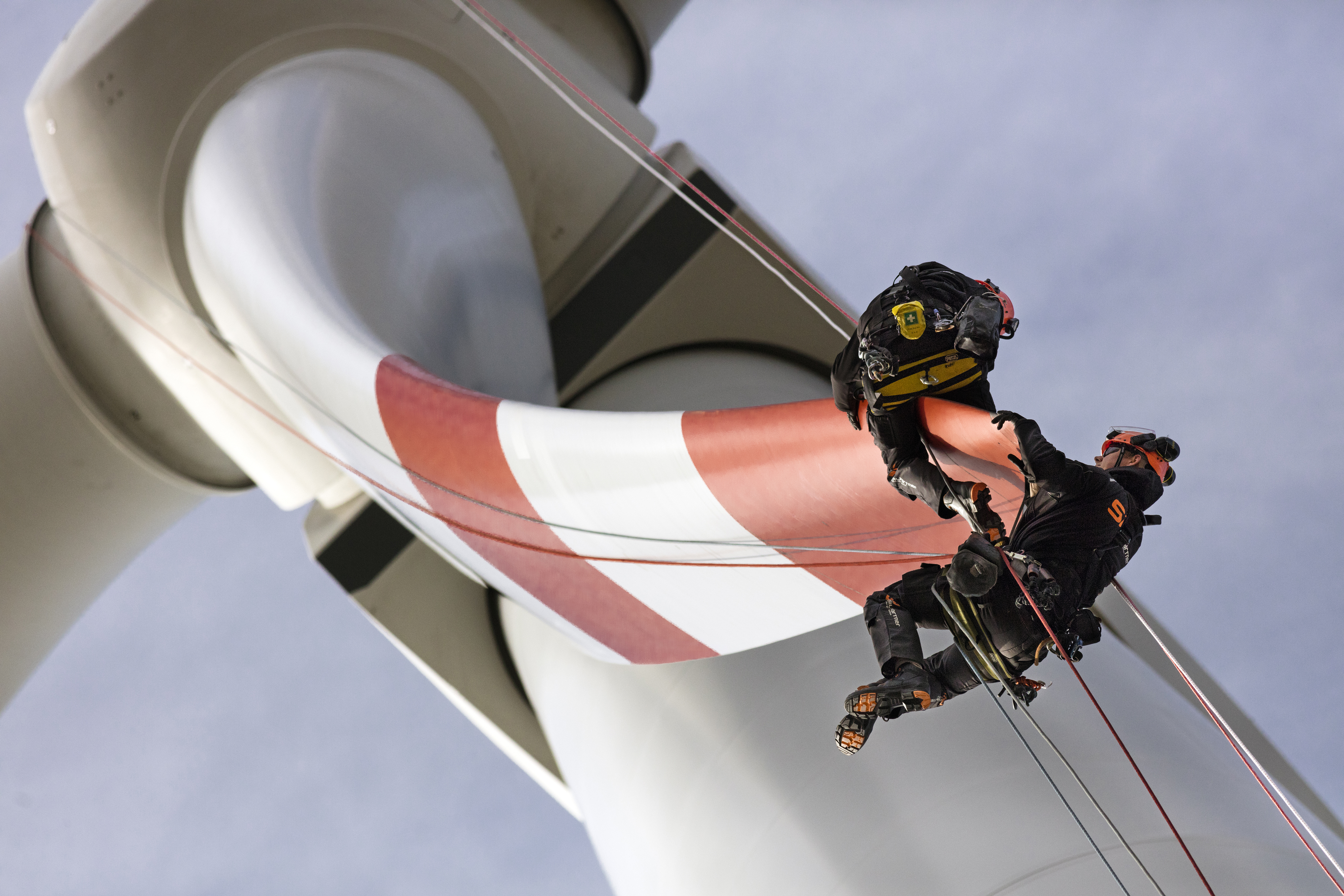 “Like spidermen two windfarm technicians working with ropes, routinely checking blades of a windturbine high above and free from giddiness. Lindenberg near Berlin, Brandenburg, Federal Republic of Germany. 23rd of March 2017.”